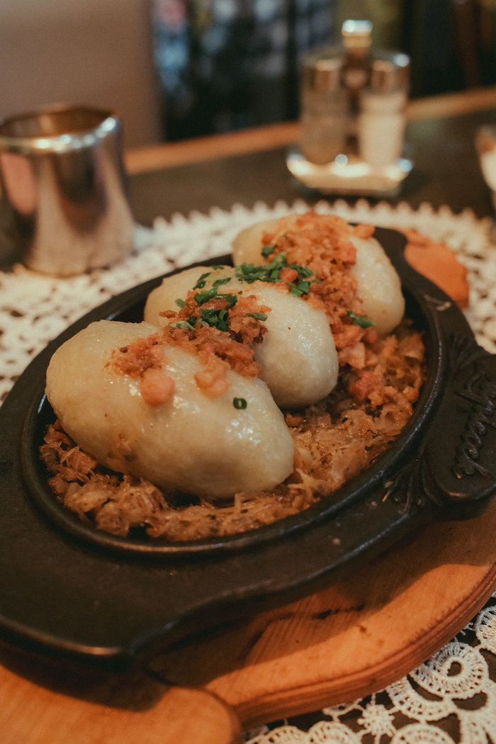 Delicious traditional Polish dumplings served with fried onions and herbs on a plate.
